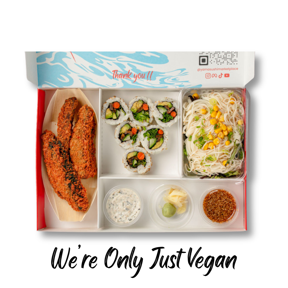 A food box featuring crispy fried strips, sushi rolls, cold noodles with corn, and condiments like wasabi and pickled ginger.